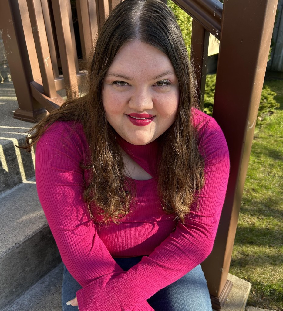 Author Madeline Nixon, a fabulous young white woman with long wavy brown hair wearing a keyhole magenta sweater and a correlating lip colour.

The header and feature image for this post is of Madeline's 2 presently-available books and the upcoming anthology (as mentioned in this post) and the image gallery in this post is a closer look at those same 3 covers. 